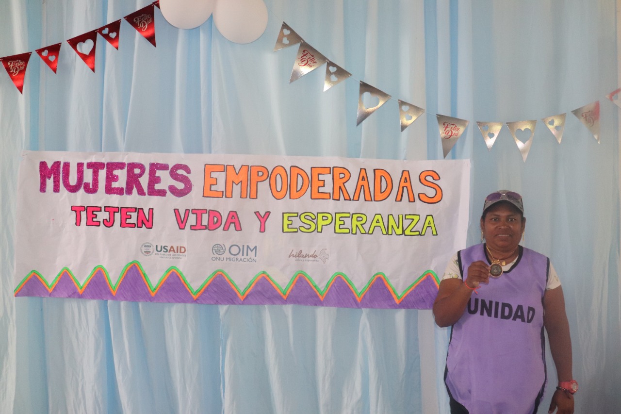 Beneficiaria mostrando su medalla obtenida durante las actividades del dia de la mujer 2022